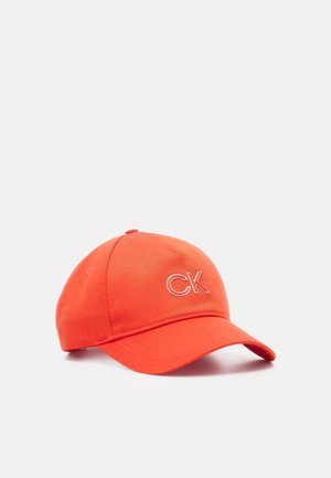 Fel oranje baseballpet met het witte "CK"-logo geborduurd aan de voorkant, weergegeven tegen een effen lichte achtergrond.