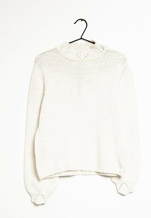 Pull en tricot de couleur crème avec des manches longues, un ourlet et des poignets côtelés, et un col rond texturé, accroché à un cintre noir.