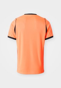 Lyse oransje, kortermet treningsskjorte med svart krage og ermepynt, vist bakfra på ensfarget bakgrunn.