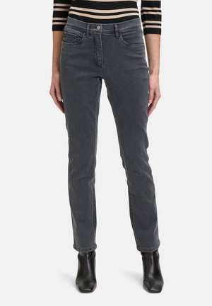 Jeans skinny in denim grigio con vita media, dotati di tasche anteriori e una texture liscia e elegante. Abbinati a stivali alla caviglia neri.