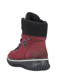Czerwone zamszowe botki za kostkę z czarnym dzianinowym kołnierzem, z czarnymi sznurowadłami i teksturowaną czarną gumową podeszwą. Akcentowane naszywką z logo.