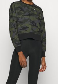 Felpa camouflage in tessuto verde e nero, con maniche lunghe, scollo rotondo e orlo a coste nero. Piccolo logo bianco sul petto.