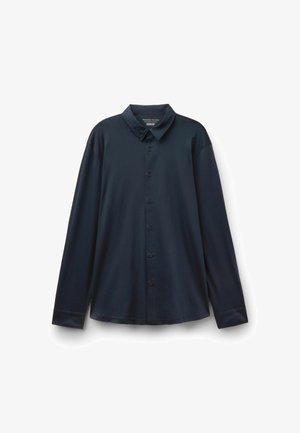 Dunkel marineblaues Hemd mit langen Ärmeln, Kragen, sieben schwarzen Knöpfen und leicht geschwungenem Saum vor weißem Hintergrund.