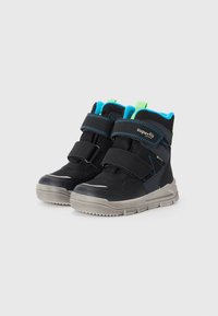 Schwarze High-Top-Schuhe mit Klettverschlüssen, die ein blaues und grünes Innenfutter haben. Gummisohle mit strukturiertem Grip, silberne Akzente an der Vorderseite.