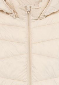 Giacca trapuntata beige con zip centrale e cappuccio dotato di bottoni a pressione e coulisse.