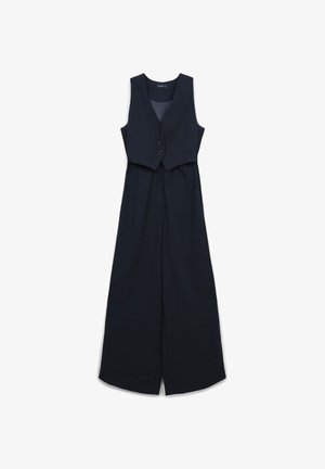 Jumpsuit blu navy con un gilet aderente e corto, cinque bottoni e pantaloni a gamba larga. Tessuto morbido e linee pulite creano un silhouette su misura.