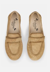 Helle Mokassins aus Wildleder mit runder Zehenpartie, gesteppten Details und einem dezenten Schmetterlingslogo. Flache Sohle mit weicher Textur.