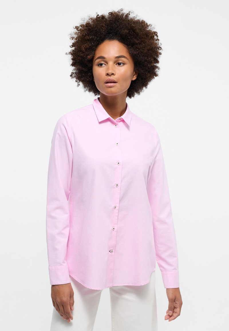 Helles rosa Langarmhemd mit Button-Down-Kragen, das einen abgerundeten Saum und glänzende Knöpfe entlang der Vorderblende aufweist. Glatte Stoffstruktur.