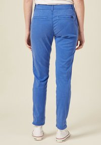 Blauwe katoenmix broek met een slim fit, twee achterzakken en subtiele stiksels, gecombineerd met witte sneakers.