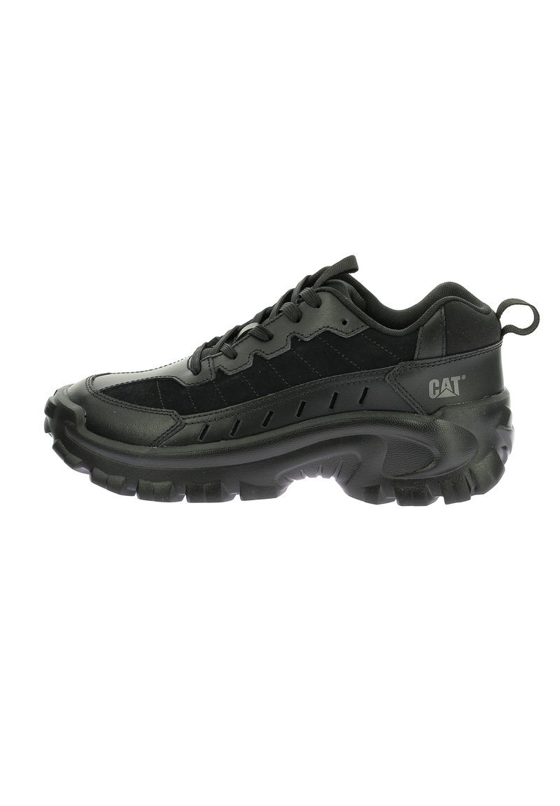 Scarpa sportiva nera realizzata con un mix di materiali in pelle e camoscio. Presenta una suola spessa, un sistema di allacciatura prominente e un piccolo anello sul tallone.