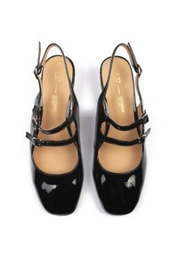 Des chaussures Mary Jane en cuir verni noir avec un bout carré, deux brides croisées, une boucle réglable et une semelle intérieure en tan rembourrée.