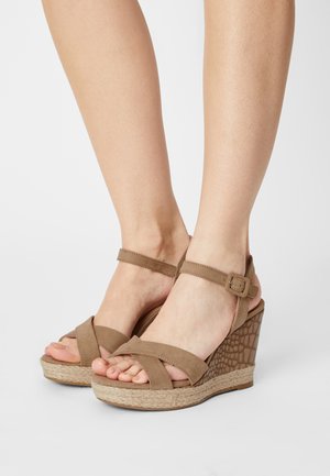 Brown wedge sandals with a textured heel, adjustable ankle strap, and crossband design; made of suede and jute.