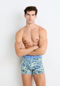 Ανδρικά boxer briefs με μπλε ελαστική ζώνη που φέρει το λογότυπο "BJÖRN BORG". Διακοσμημένα με σπειροειδείς πράσινους, μπλε και λουλουδάτους σχεδιασμούς.