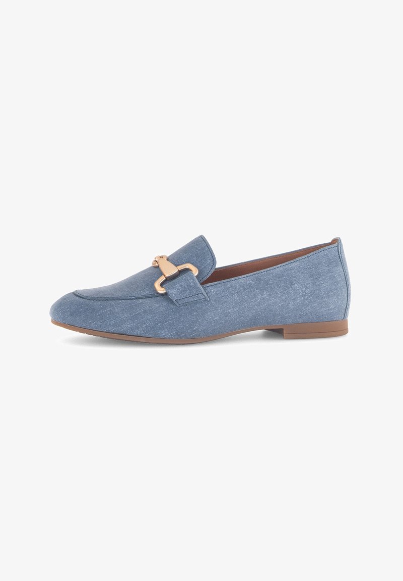Mocassins de tecido azul com sola plana, apresentando uma fivela decorativa em tom dourado na parte da frente e uma textura suave.