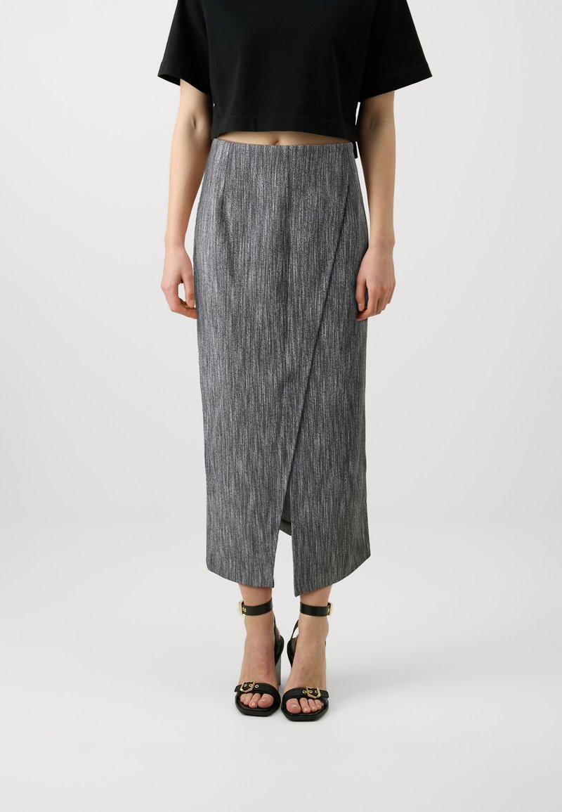 Gray wrap skirt with vertical textured pattern, knee-length, side slit; paired with black sandals featuring gold accents and ankle straps.