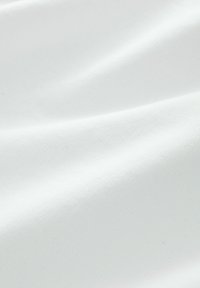 Tissu blanc avec une texture lisse, légèrement froissé, présentant un tissage dense qui met en valeur sa couleur claire et son éclat subtil.