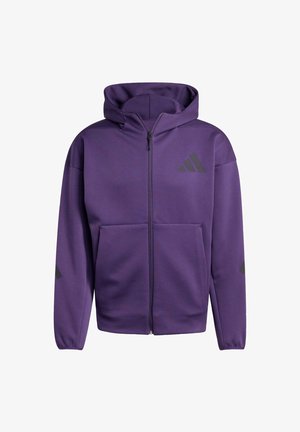 Haut à zip violet en tissu lisse, doté d'une poche avant, d'accents en logo noir et d'une capuche pour une protection supplémentaire.