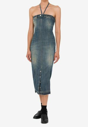 Abito midi in denim blu sbiadito senza spalline con bottoni sul davanti, indossato con calze nere e mocassini neri.