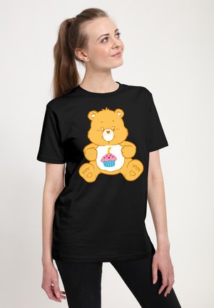 Sort t-shirt med et tegneserie-bjørn med en cupcake-design på forsiden. Bjørnen er orange med lyse farver og et muntert udtryk.