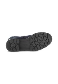 Suela de goma negra de un zapato con surcos profundos, que presenta una punta redondeada y una parte superior lisa sin herrajes ni patrones visibles.