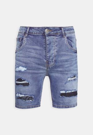 Blaue Denim-Shorts mit verwaschenen Stellen, die schwarzen Stoff darunter sichtbar machen, mit Frontknopf, Reißverschluss und Seitentaschen.