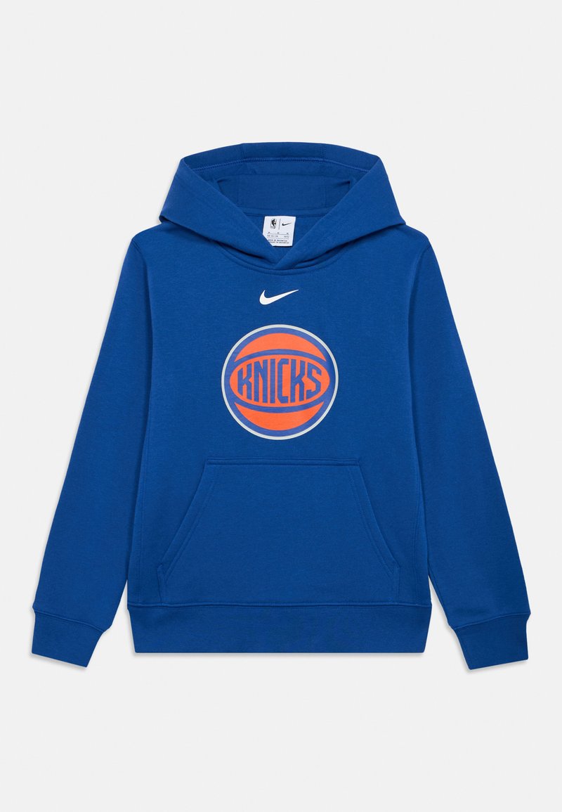 Modrá mikina s kapucí vyrobená z měkké tkaniny, se přední kapsou. Má kulatý logo s textem "KNICKS" a nad ním ikonický znak Nike.