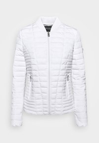 Veste blanche matelassée zippée avec col côtelé et deux poches latérales zippées, présentant des motifs de couture horizontaux et verticaux.