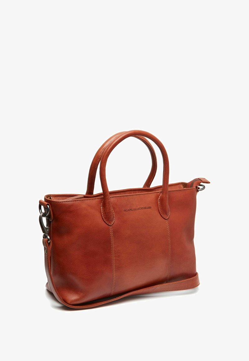 Bruine leren tote bag met twee ronde handvatten, gestructureerde vorm, contrasterende stiksels en een ritsluiting; heeft een metalen accent.