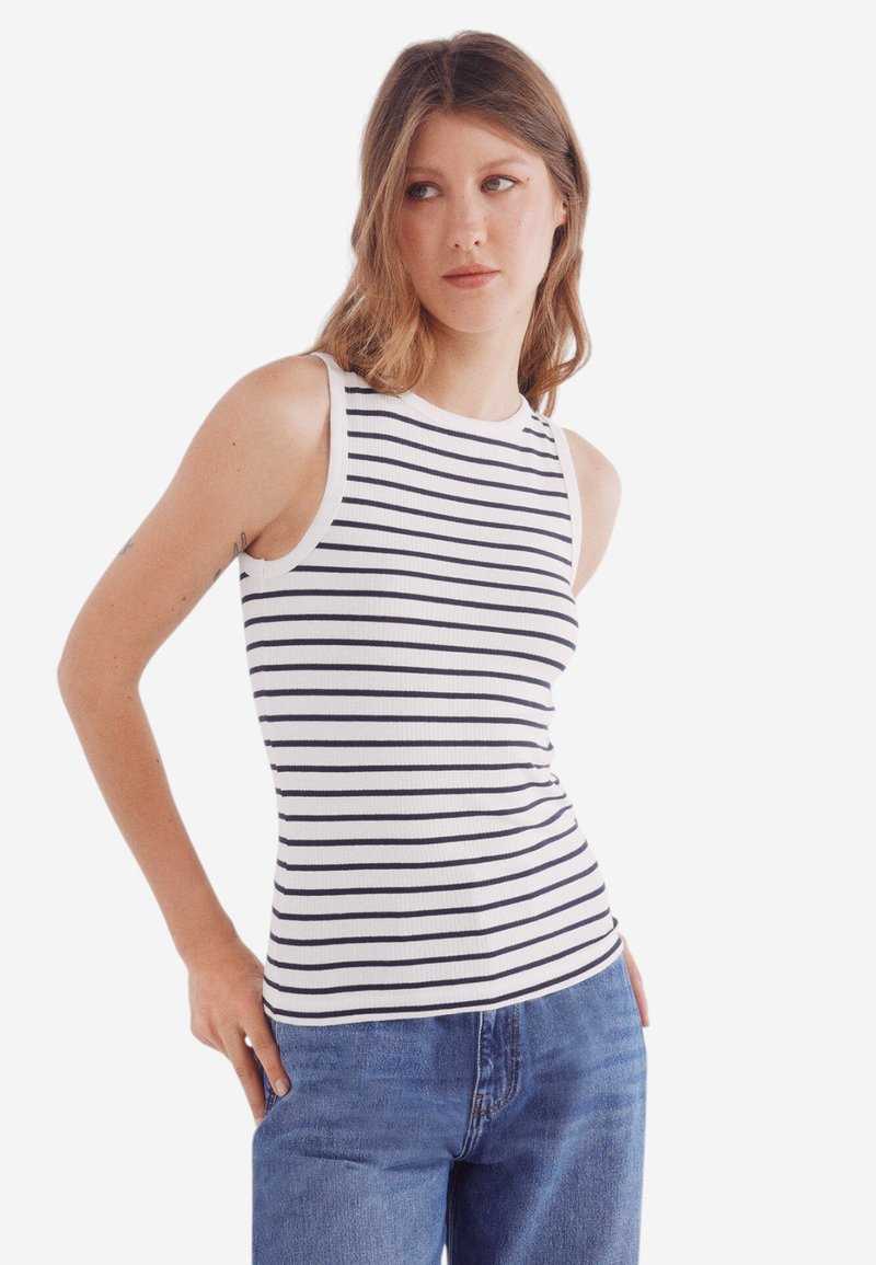 Gestreift ärmelloses Oberteil mit weißen und dunkelblauen horizontalen Streifen. Verfügt über einen runden Halsausschnitt und ärmelloses Design. Kombiniert mit hellblauen Jeans.