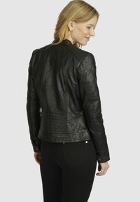 Black leather jacket with a fitted design, shoulder seams, quilted texture on the back, and button detailing on the cuffs.