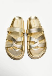 Gold slide sandals with a smooth metallic finish, featuring two wide straps and a woven accent. Rounded toe and cushioned footbed.