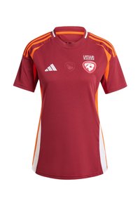 Bordo nogometna majica s narančastim i bijelim naglascima. Ima kratke rukave, okrugli ovratnik i logotipe sprijeda, izrađena je od prozračnog materijala.