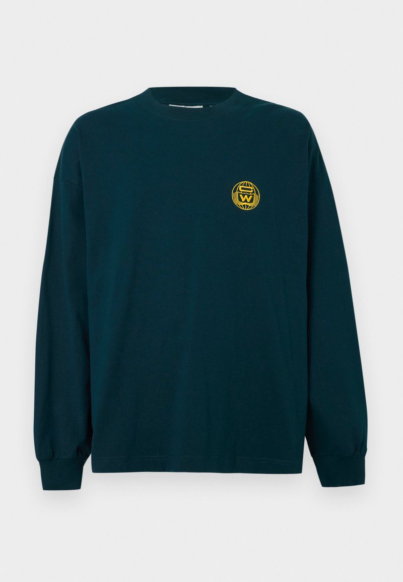 Long-sleeve T-shirt in dark blue cotton with a round neckline, featuring a yellow circular logo on the left chest. Smooth texture.