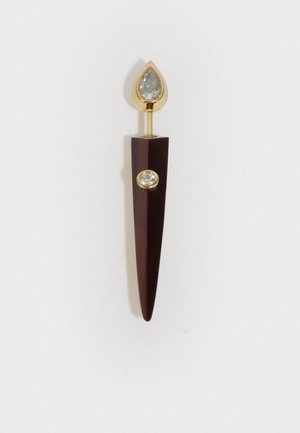 Broš s zlatnim akcentima koja ima tamnocrvenu šiljastu bazu sa dijamantnom sličnom draguljom i bisernim prozirnim kamenjem na vrhu.
