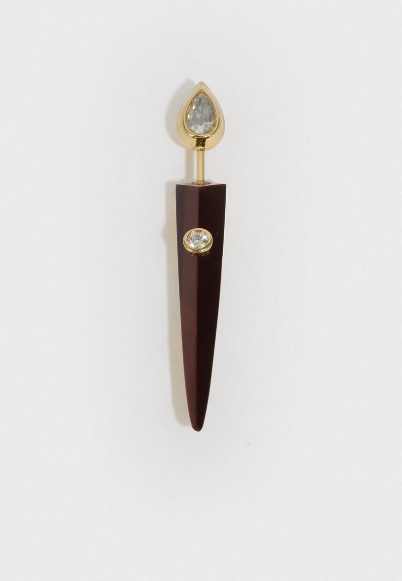 Brošňa so zlatými akcentmi, ktorá má temne červený špicatý základ s diamantovitou gemou a hruškovým čírym kameňom na vrchu.
