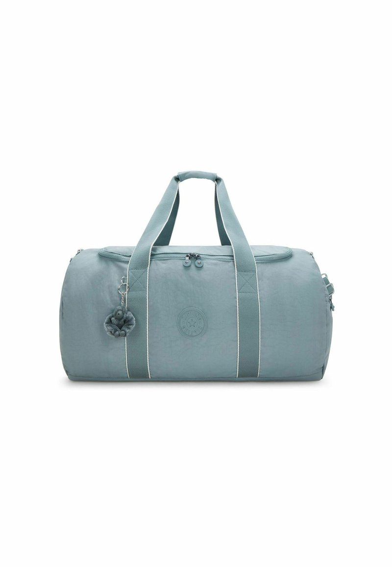 Lichtblauwe cilinder-vormige sporttas met dubbele handvatten, voorrits, logo patch en een kleine pluche sleutelhanger bevestigd aan één handvat.