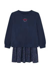 Sudadera navy de manga larga y cuello redondo, con un pequeño logo. Adjunto hay una falda plegada con un patrón de lunares en rojo, blanco y azul.