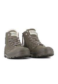 Bruine leren enkelboots met een getextureerde rubberen zool, vetersluiting aan de voorkant en een rits aan de zijkant. Voorzien van een zachte voering en een merklabel op de tong.
