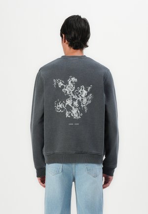 Gray crewneck sweatshirt featuring a textured white floral print on the back. Ribbed cuffs and hem, relaxed fit, and soft fabric.
