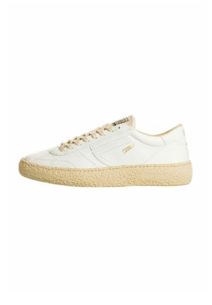 Sneaker bianca low-top con suola beige testurizzata, lacci beige e marchio dorato discreto su lato e linguetta.