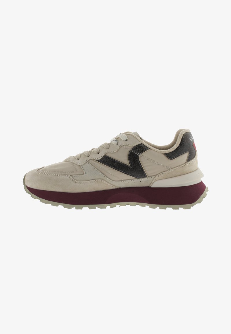 Sneaker in suede e pelle beige con una striscia texturizzata nera, suola bordeaux, passanti per lacci grigi e un collare leggermente imbottito.