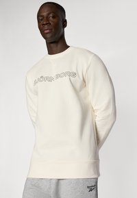 Cremfarbener Sweatshirt aus weichem Stoff, mit Rundhalsausschnitt und gerippten Bündchen. Schwarzes "BJÖRN BORG" Logo auf der Brust aufgedruckt.