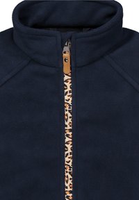 Marinblå fleecejacka med hög krage, med en dragkedja i leopardmönster. Mjuk textur, dragkedjestängning och kontrasterande detaljer fram.