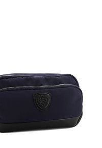 Borsa da toeletta blu navy con due scomparti con zip, dotata di una patch in pelle nera e di un fondo texturizzato per stabilità.