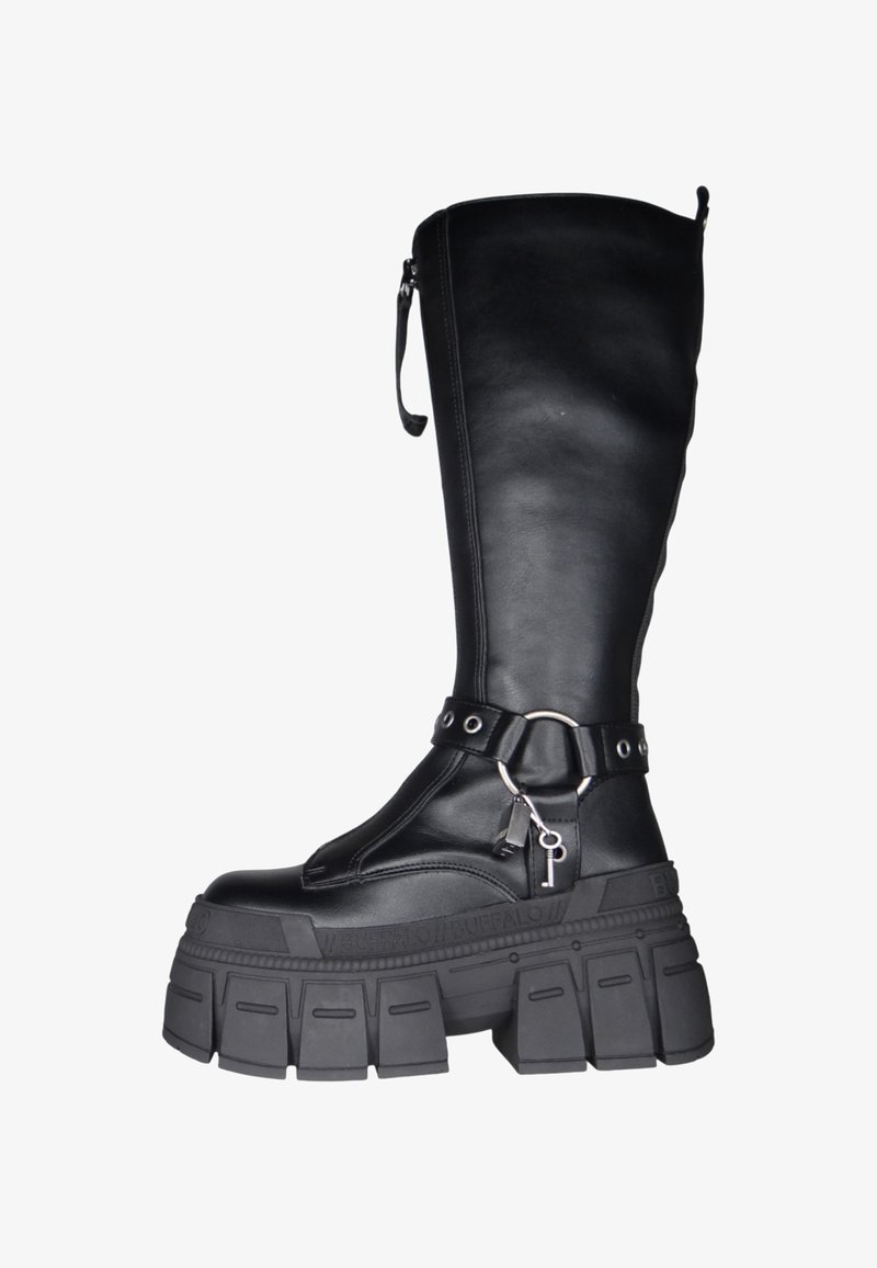 Μαύρες δερμάτινες μπότες μέχρι το γόνατο με χοντρό καουτσούκ πάτο. Διαθέτουν φερμουάρ στο πλάι, λουρί με μεταλλικό εξάρτημα σε σχήμα δαχτυλιδιού και λεπτομέρειες με λογότυπο.