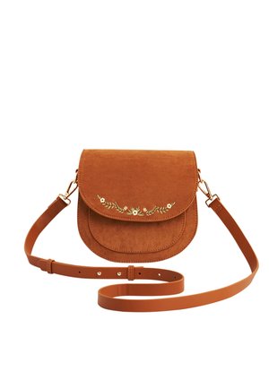 Bolso bandolera de ante marrón con correa ajustable y pequeño bordado floral blanco en la solapa frontal.