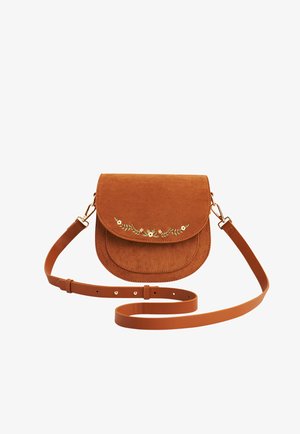 Sac bandoulière en daim marron avec sangle réglable et petite broderie florale blanche sur le rabat avant.