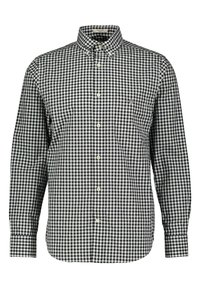 Black and white checkered button-up shirt with a collar, long sleeves, and a chest pocket. Made of woven fabric, features a curved hem.