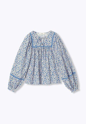 Blouse à manches longues avec motif floral bleu et blanc, encolure carrée bordée d'un ruban bleu, et tissu froncé sous la poitrine.
