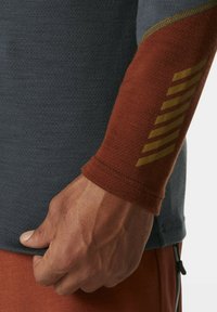 Sportieve longsleeve t-shirt in donkergrijs met roestbruine mouwen. Voorzien van gouden diagonale strepen op de mouwen, een gestructureerde stof en een getailleerd ontwerp.
